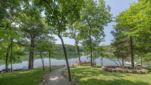 A gravel path leading to a wooden dock by a calm lake, surrounded by lush green trees. - Reflection Point by Innsbrook Vacations! (Innsbrook)