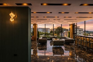 Un intérieur moderne comprenant un coin salon, une vue sur le paysage urbain et un luminaire décoratif.