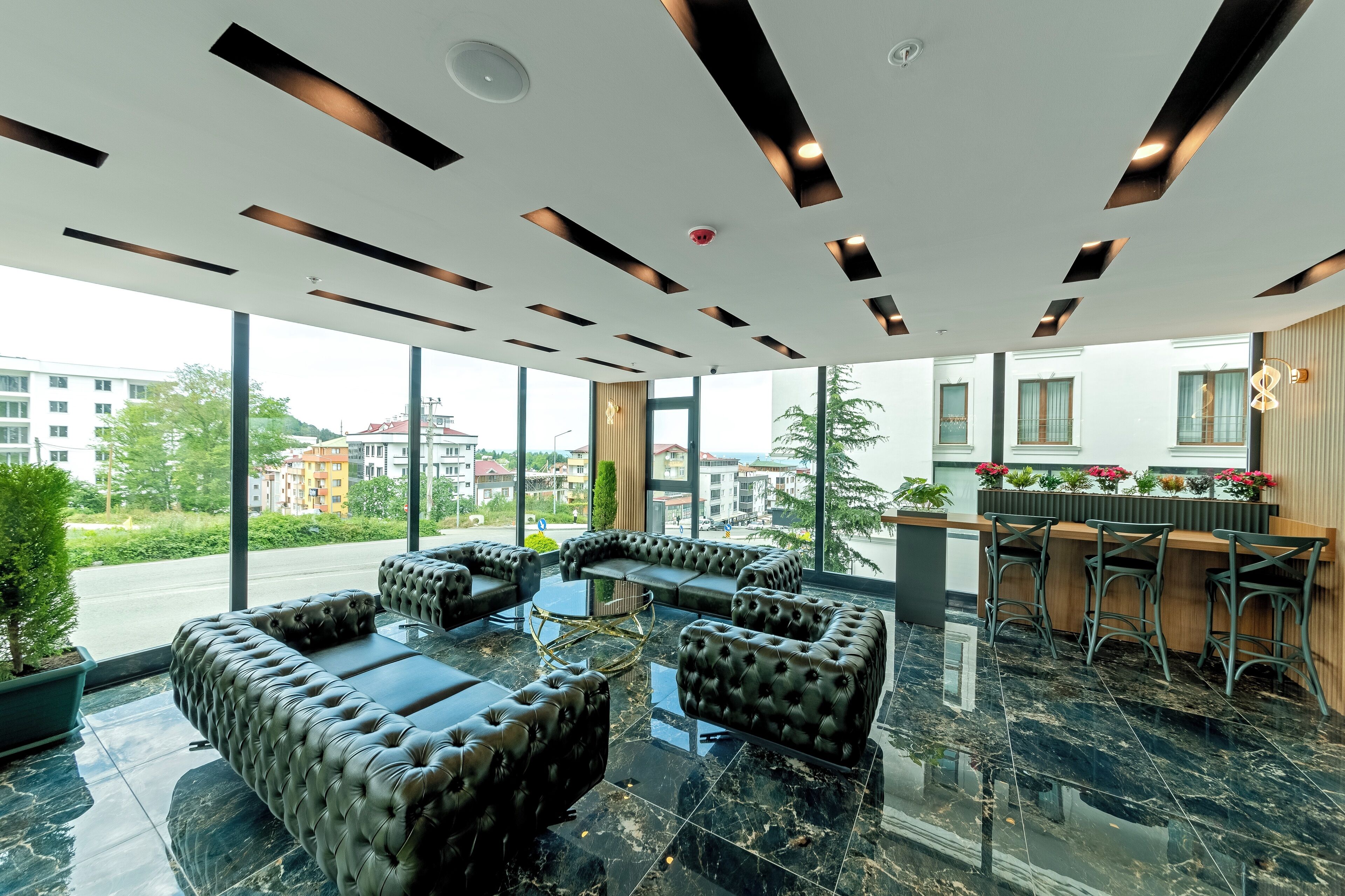 Un espace lounge moderne avec des canapés en cuir et un bar doté de tabourets.