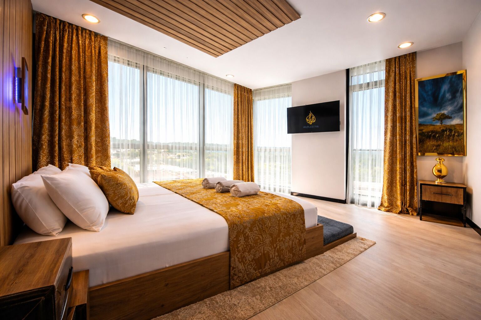 Een moderne hotelkamer met een groot bed, een flatscreen televisie en uitzicht over de stad.