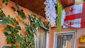 Una entrada acogedora con techo de madera, una puerta de cristal con el número 30 y una bandera suiza.