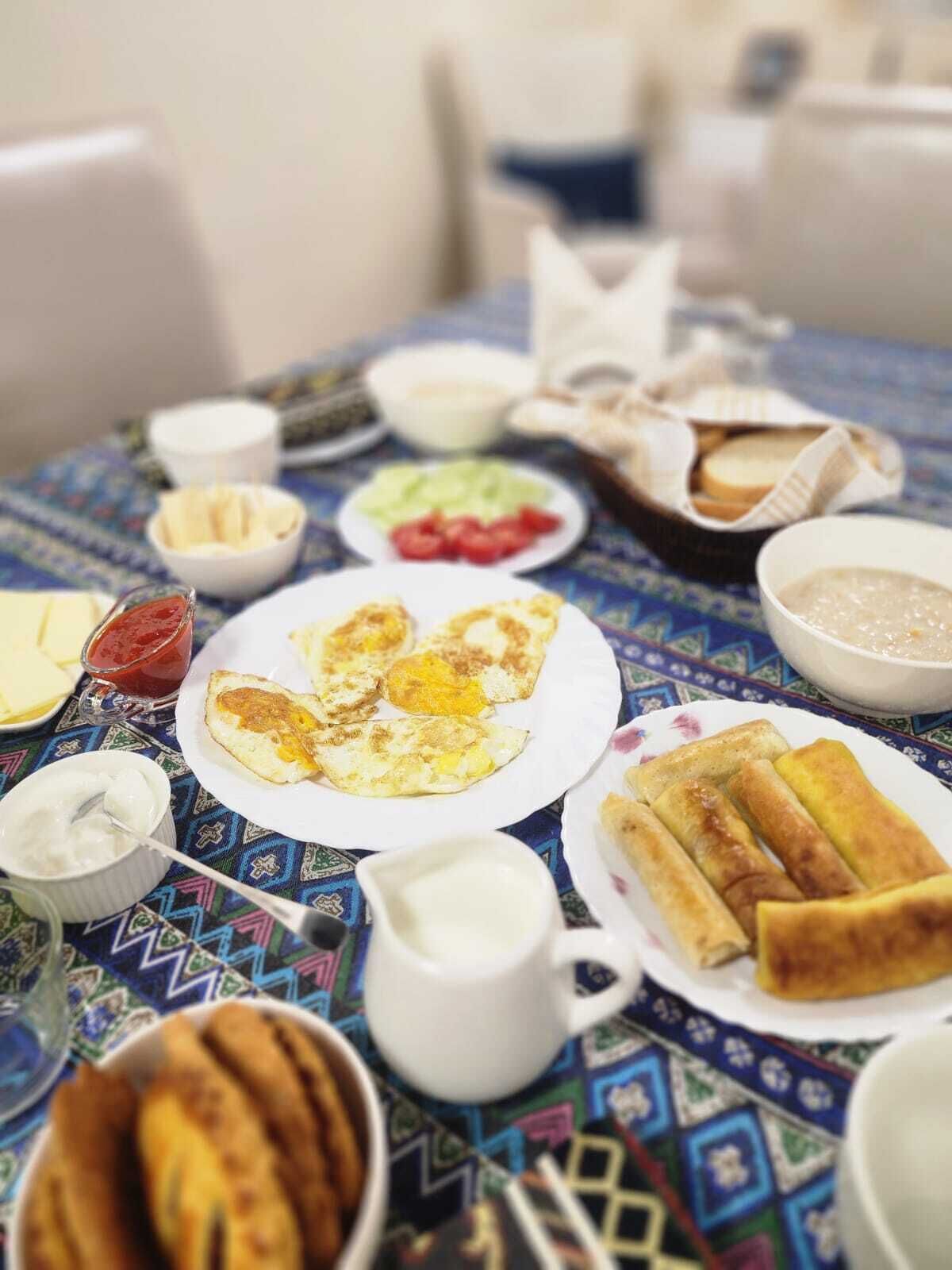 A table with various breakfast items including eggs, bread, and condiments.