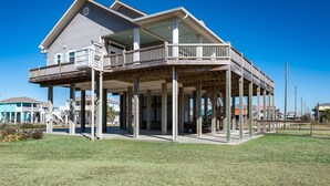 A two-story house with a balcony and a covered porch area.