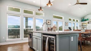A spacious kitchen with a large island, built-in appliances, and a view of the outdoors.