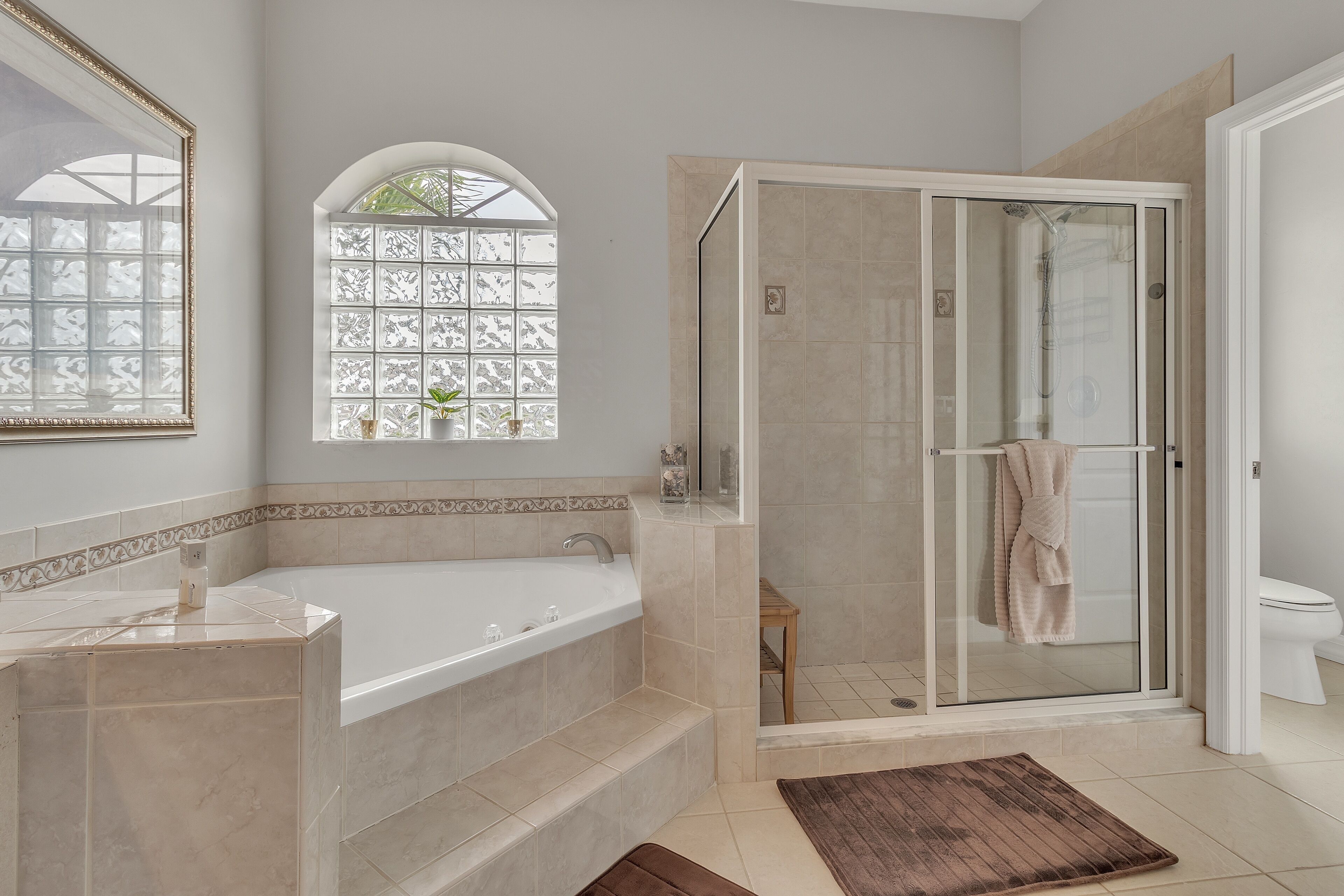 Un baño moderno con una bañera independiente, ducha con mampara de vidrio y tocador con espejo.