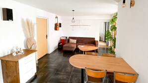 A modern living space with a dining area, a sofa, and a guitar on the wall. - Villa Accueillante et Familiale (La Garde)