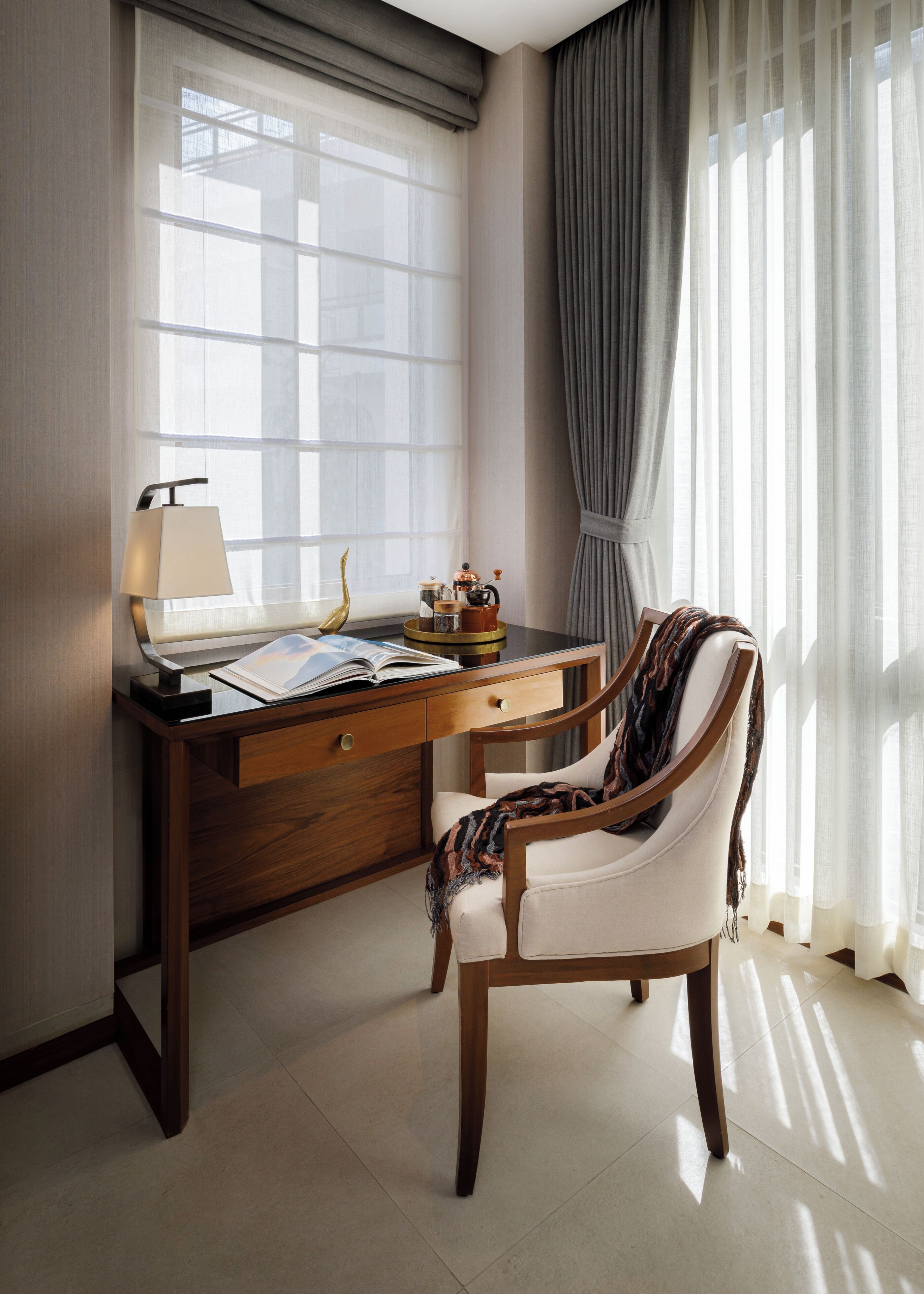 Een moderne kantoorruimte met een houten bureau, een lamp en een stoel.