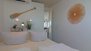A bedroom with two beds, a paddle wall decor, and a circular wall art piece. - Hausboot in Boltenhagen (Boltenhagen)