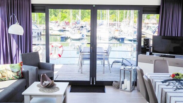 Een moderne woonkamer met uitzicht op een jachtsteiger.