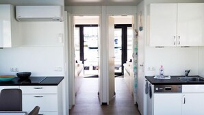 Een moderne keuken met witte kasten, een zwart aanrecht en een vaatwasser. Er is een raam met uitzicht op buiten.