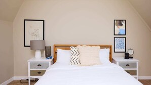 A bedroom with a bed, two nightstands, a lamp, and framed artwork on the walls. - The Holland Park Crib - Classy 2bdr House (London)