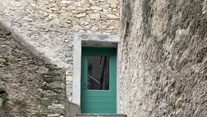 A set of stone steps leading to a green door, flanked by rough stone walls. - Stylish duplex on an award-winning vineyard; shared pool; close to the Cevennes (Brissac)