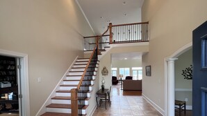 Un vaste espace de vie agrémenté d’un escalier en bois menant à un niveau supérieur.