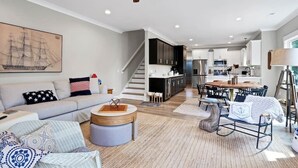 Un salon moderne comprenant un canapé, une table basse et un coin repas avec des chaises et une table.