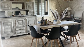 A dining area with a wooden table, black chairs, and a chandelier.