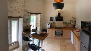 A compact kitchen with a central island, a microwave, a stove, and a sink.