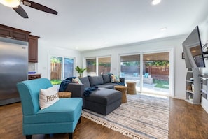 Relax in this spacious living room with a large sofa, armchair, and flat-screen TV.