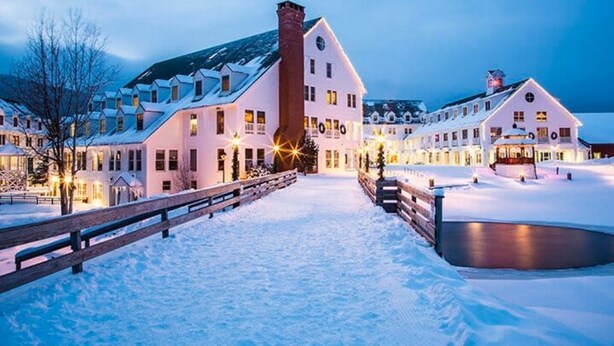 Un hotel cubierto de nieve con varias construcciones conectadas por un sendero.