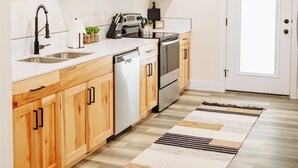 Una cocina moderna con armarios de madera, electrodomésticos de acero inoxidable y una isla central.