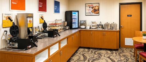 Eine Hotelküche mit Waffeleisen, einem Kühlschrank und einer Kaffeestation.