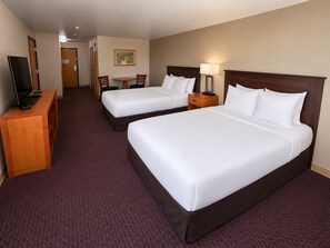 A hotel room with two beds, a desk, a TV, and a painting on the wall. - Hotel Mar Vista (Ocean Shores)