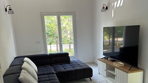 Una sala de estar moderna con un sofá seccional, un televisor de pantalla plana y un mueble de madera.