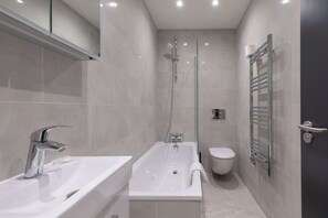 Une salle de bain moderne avec une baignoire, un lavabo et des toilettes.
