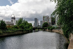 Une rivière bordée de bâtiments des deux côtés, dont une tour remarquable.