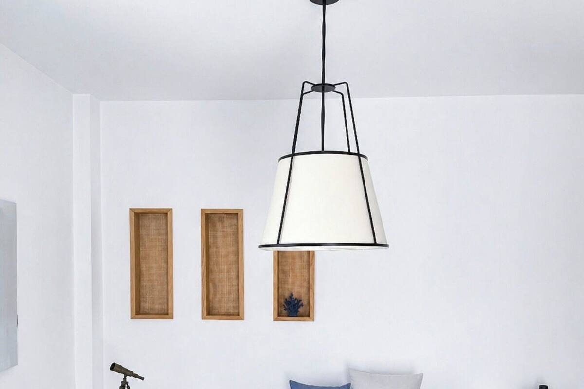 Una sala de estar moderna con un sofá, una mesita redonda pequeña, una lámpara de pie y dos marcos con cuadros en la pared.