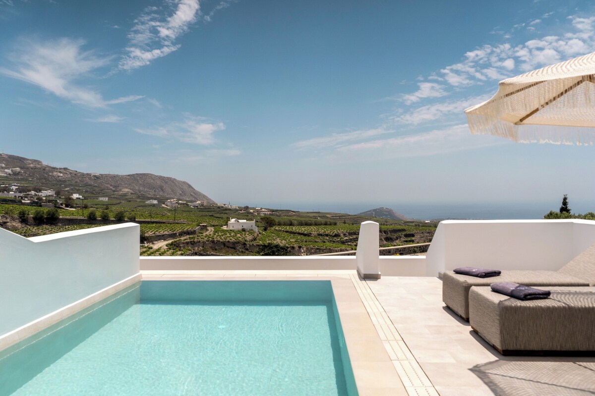 A rooftop pool with a view of the landscape and distant mountains.