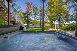 Een hottub met uitzicht op een meer en bomen.