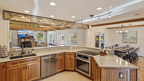 A spacious kitchen with wooden cabinets, a built-in oven, and a granite countertop.