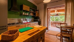 A kitchen with wooden cabinets, a green countertop, and a view of an outdoor patio with a table and chairs. - Villa La Pieve - Nine Bedroom Villa, Sleeps 20 (Città della Pieve)