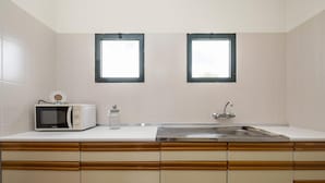 A kitchen with a microwave, a jar, and a sink. - Escapadinha do Sol by Homie (Porto Santo)