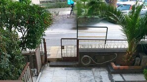 A set of marble stairs leading to a gated entrance with a metal barrier and a parked vehicle. - Rooftop 1 Bdr Apt - Metro Cholargos - 5 Min Walk (Papagou-Holargos)