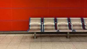A waiting area with a red wall and a sign that reads "Холарюс Холаргос". There are metal benches aligned against the wall. - Rooftop 1 Bdr Apt - Metro Cholargos - 5 Min Walk (Papagou-Holargos)