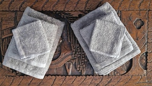 Two folded towels on a wooden table with intricate carvings. - Rooftop 1 Bdr Apt - Metro Cholargos - 5 Min Walk (Papagou-Holargos)