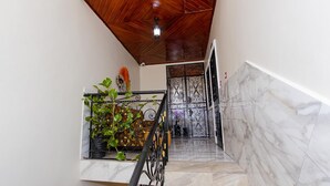 A staircase with a wooden ceiling, a metal railing, and a wall with a decorative metal gate.