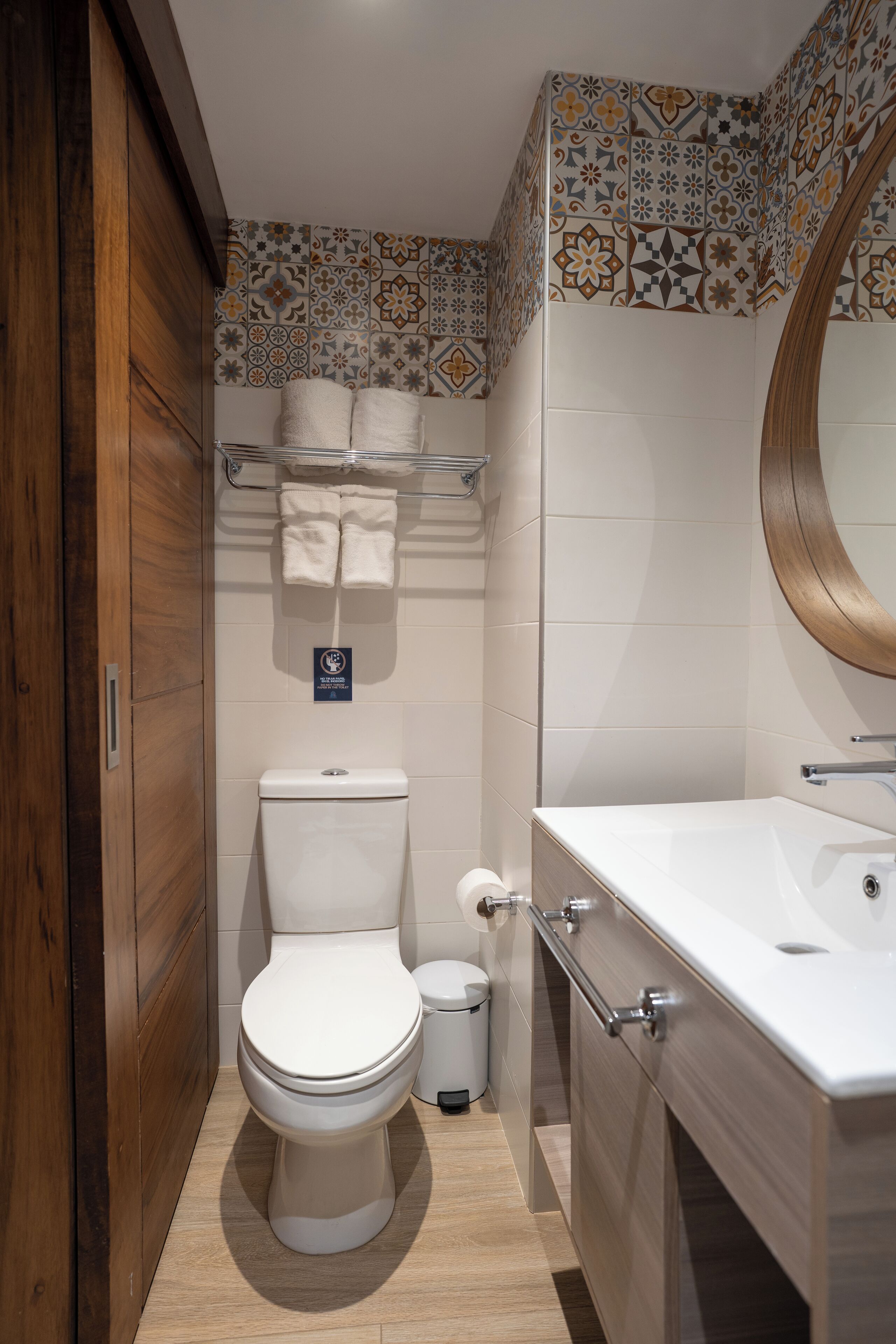 Un baño pequeño con inodoro, lavabo y espejo.
