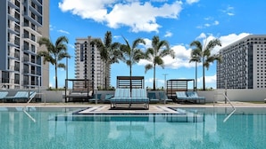 A swimming pool with lounge chairs and palm trees, surrounded by high-rise buildings. - Location, location, location. Best area of Doral (Doral)