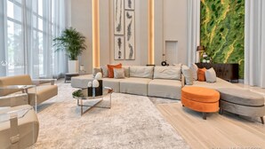 A modern living room with a sectional sofa, a glass coffee table, and a green textured wall. - Location, location, location. Best area of Doral (Doral)