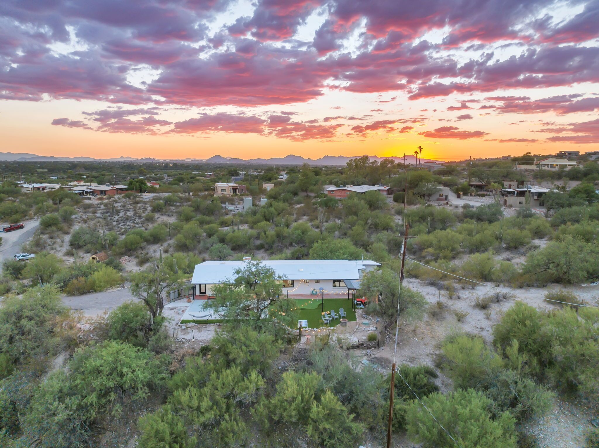 A house with a large patio, surrounded by desert vegetation.