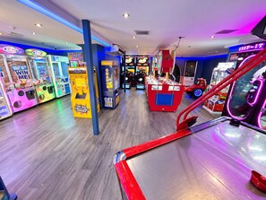 Un salón de juegos recreativos con diversas máquinas de videojuegos y de garra.