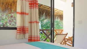 A bedroom with a bed, curtains, and a view of greenery outside. - Yoo Bigu Mazunte (Santa María Tonameca)