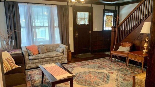 A cozy living room with a sofa, a bench, a coffee table, and a patterned rug. - Boho Bungalow off Main-one block from Lovely Park (Richmond)