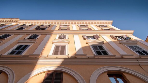 A multi-story building with classical architecture, featuring arched windows and a symmetrical facade.