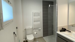 Un bagno moderno con servizi igienici, bidet e cabina doccia in vetro.