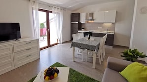 Un appartamento moderno con zona pranzo, angolo cottura e soggiorno.