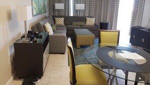 A modern living room with a sofa set, a glass coffee table, and a small round table. - 2 BR - Resort -2 Suite En Orlando Kissimmee, Cerca a los Parques Temáticos (Kissimmee)