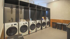 Filas de lavadoras de carga frontal en un lavadero público.